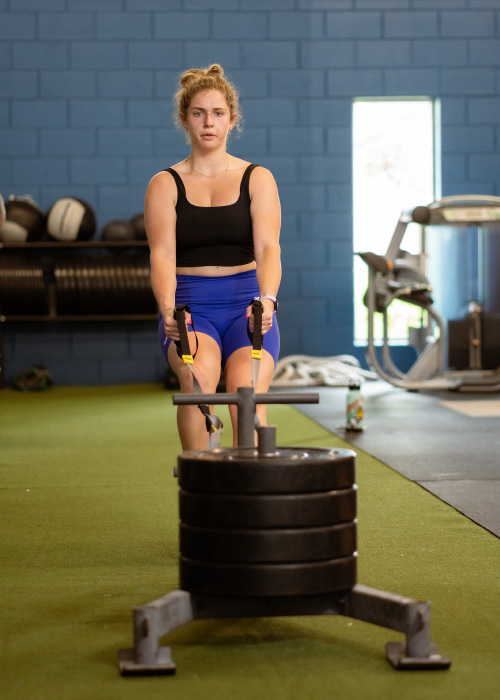 Woman dragging sled through turf